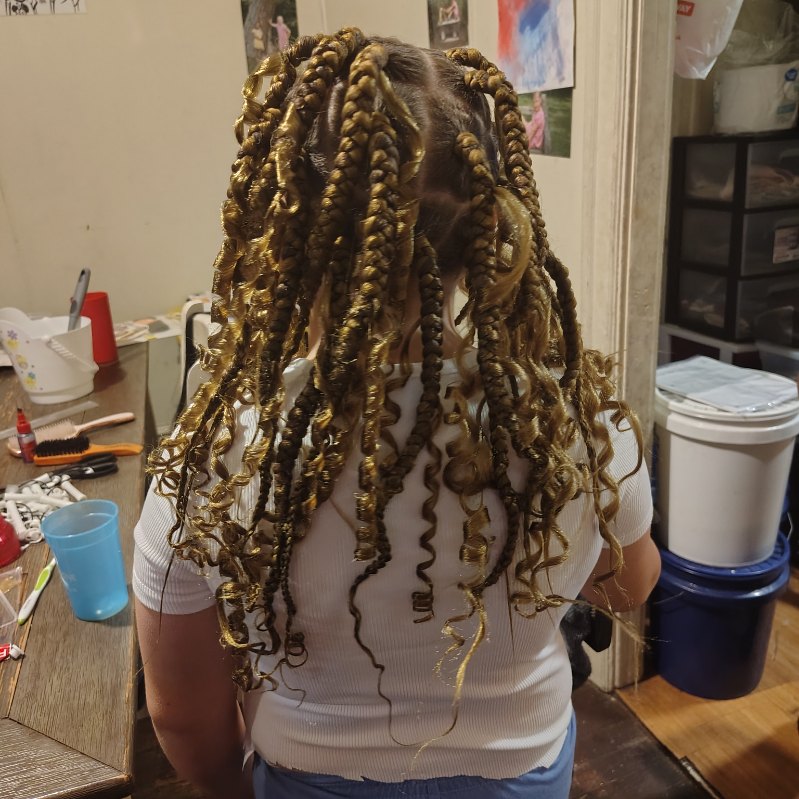 Long braids wrapped in gold cord, seen from behind